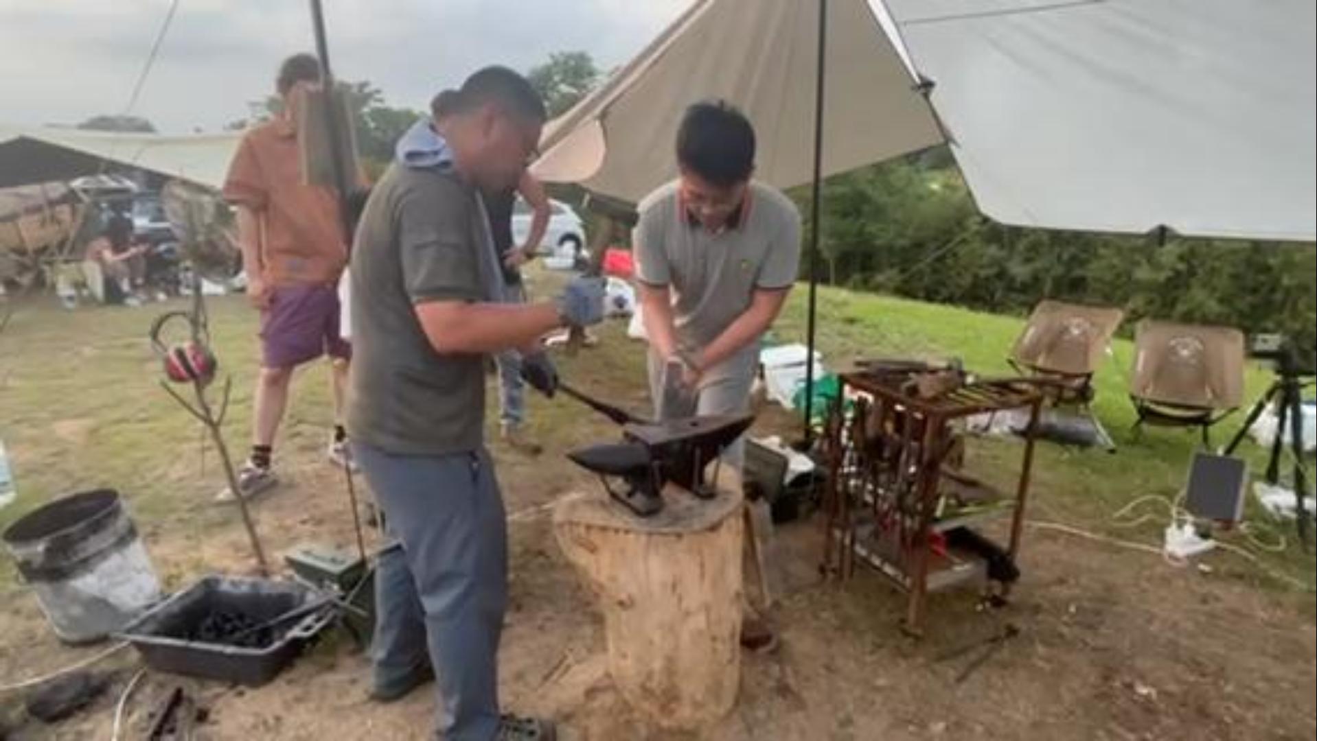 Trying blacksmithing at an outdoor camping festival